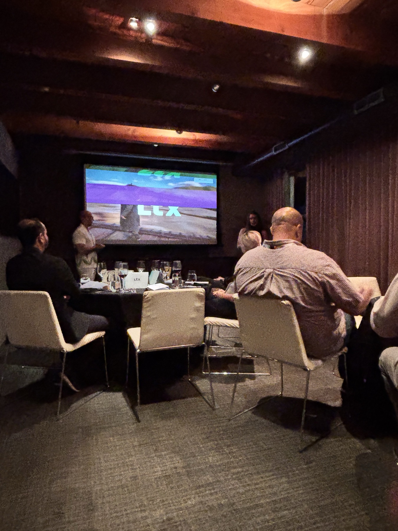 The LTX team gives a concise presentation to guests seated around dinner tables.