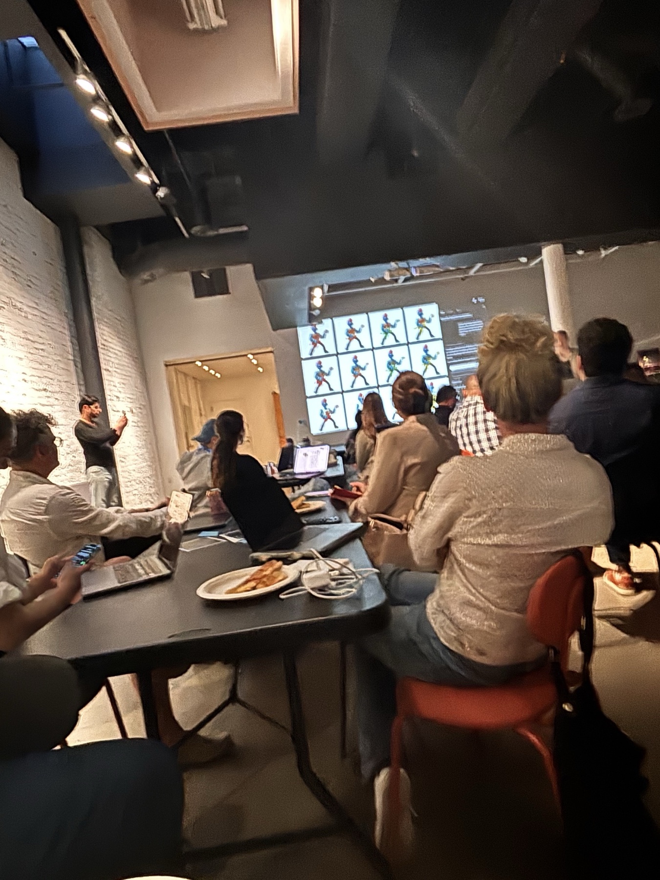 Creators seated with laptops while Luma's team demonstrates generated character variations on a large screen.