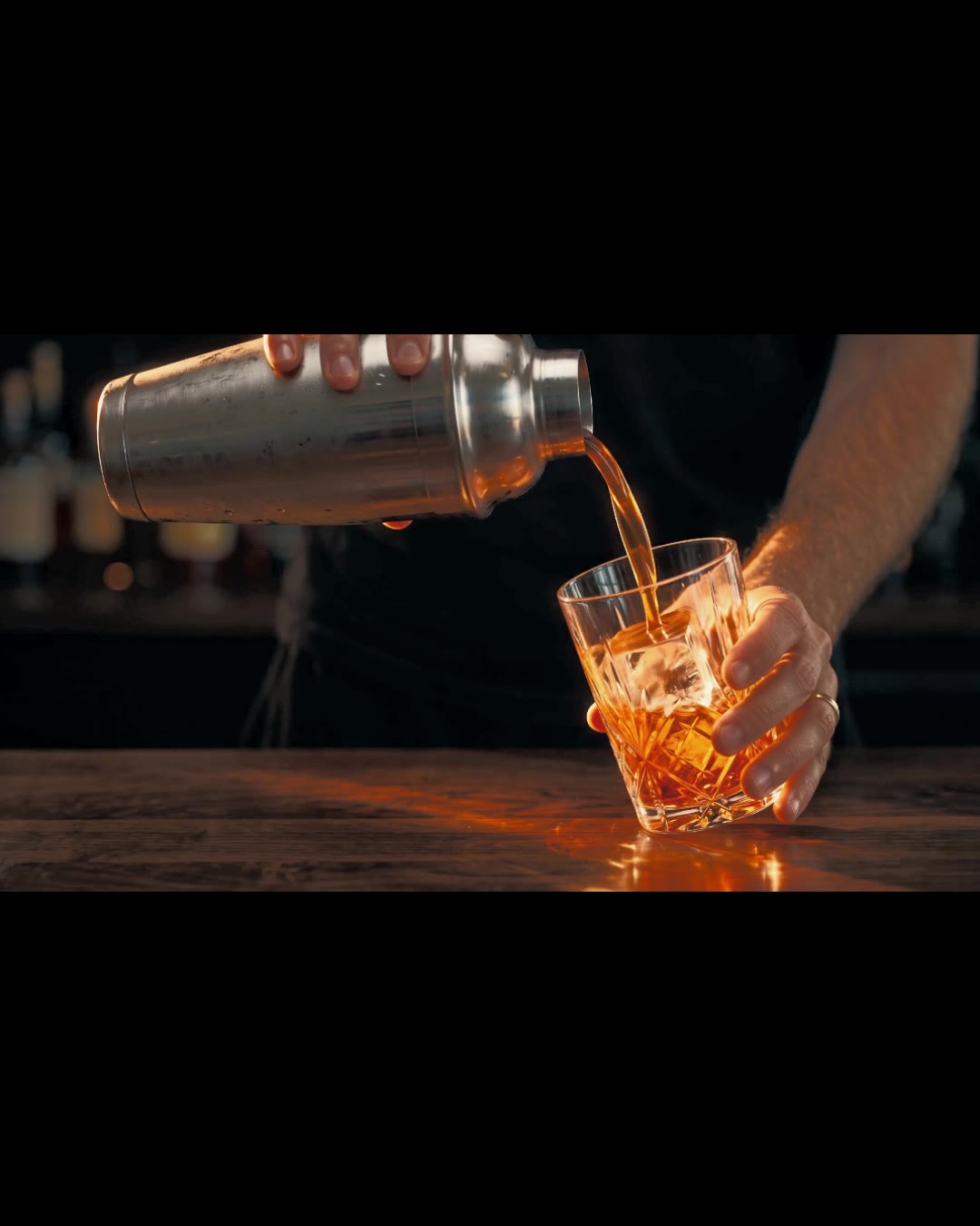 The VESPERTINE spec spot, a shaker pouring an amber aperitivo over ice