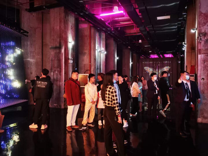 Guests gathered in the neon-lit venue among planting