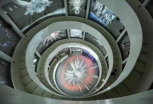 A spiral staircase lined with curved immersive projection screens