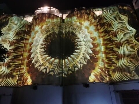 A golden mandala projected across the curved silo wall